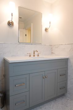 a bathroom with two sinks and a large mirror above it's cabinetry,