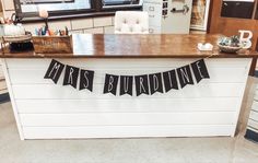 a kitchen counter with a banner that says mrs burdwine hanging from it's side