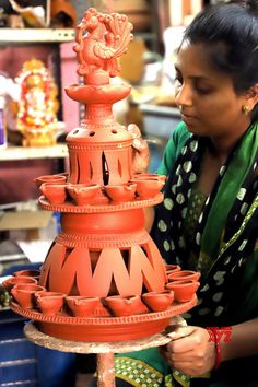 a woman is working on a clay sculpture