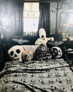 a bed topped with lots of pillows covered in skulls