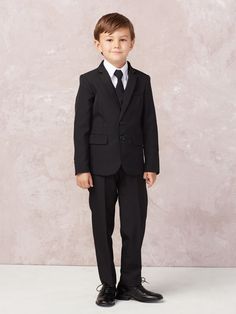 a young boy in a black suit and tie