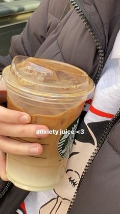 a person holding a starbucks drink in their hand