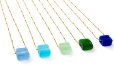 Recycled glass bottles are transformed into sea glass or beach glass style glass beads for a simple, minimalist, delicate and intriguing necklace for everyday. Glass beads are roughly .75 inch by .75 inch or smaller (they will vary in size and shape) and finished with an 18 inch gold fill chain. Modern, beach inspired, classic jewelry that is easy to wear. Sea glass matte finish highlights bright, vibrant, unique color. Gold chain necklace extender available for added length. Sea glass beads ... Bombay Sapphire, Smart Glass, Recycled Glass Bottles, Sake Bottle, Cube Necklace, Bottle Earrings, Holiday Goodies, Clear Earrings, Soda Bottle