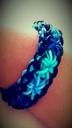 a close up of a person's arm wearing a bracelet with blue and white braiding