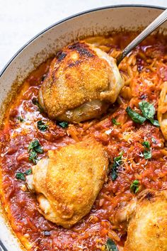 two chicken thighs in a red sauce with spinach and parmesan cheese