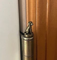 a metal dog figurine on the side of a door