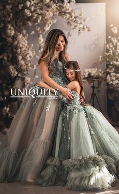 a mother and daughter pose for the camera in their gowns with flowers on them