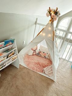 a child's teepee tent with lights on it in the corner of a room