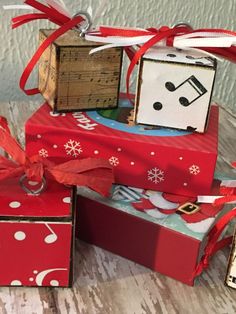 three small boxes are stacked on top of each other and tied with red ribbon bows