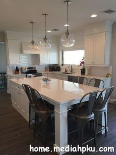 a large kitchen with an island in the middle and chairs at the counter top on the side