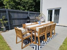 a table and chairs on a patio with a black and white rug in front of it