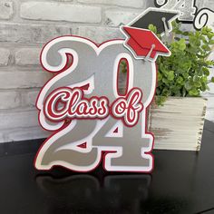 a metal sign that says class of 2014 with a graduation cap on top and the words class of 2014 below it