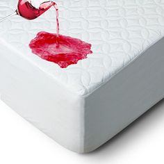 a red liquid is being poured onto a white mattress