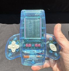 a person holding a gameboy in their left hand and playing on the other side