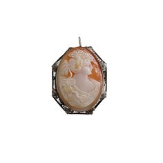 Lady with hair of flowers. This carved shell cameo depicts the figure wearing a draped dress with flowers swept up in top of hair and then again on the shoulder. Exquisitely carved. Medium Relief. This cameo is mounted in a 9K white gold filigree setting. The filigree consist of ornamental fine wire formed into delicate lace and leaves which are strategically placed throughout the pattern. Metal Tested. No maker's mark. Dimension are 1.6" x 1.1". Can be worn as either a brooch or pendant, bail f Carved Brooches For Formal Occasions, Cameo Brooches For Wedding, Cameo Pendant Brooches For Wedding, Antique White Gold Filigree Brooches, Cameo Pendant Brooch For Wedding, Gold Filigree Oval Brooch, Vintage Filigree Pendant Brooches, Vintage Filigree Pendant Brooch, Formal Cameo Pendant Brooch