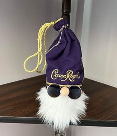 a purple bag sitting on top of a wooden table next to a pair of sunglasses