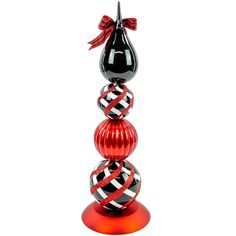 a black and white striped glass sculpture on top of a red base with a bow