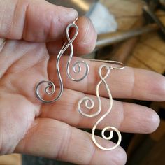 "We hammered and swirled 18 gauge sterling silver wire into these playful, elegant earrings. The earrings measure about 1 3/8- 1 5/8 \"(3.5 - 4.2cm) from the top loop to the bottom of the earrings. The earwires add about 1/2\" making them a total length of about 1 7/8-2 1/8\" (4.8-5.4cm) from the top of the sterling silver earwire to the bottom of the earring. They are about 5/8\" (1.6cm) across the widest part. Check out the Sterling Silver Wire Jewelry section of our shop to see all the other Hand Forged Sterling Silver Wrap Earrings As Gift, Silver Hand Forged Wrap Earrings As Gift, Sterling Silver Hand Forged Wrap Earrings For Gifts, Hand Forged Sterling Silver Wrap Earrings For Gift, Handmade Earrings With A Modern Twist As A Gift, Modern Twist Swirl Earrings For Gifts, Hammered Spiral Earrings As Gift, Handmade Sterling Silver Earrings With A Modern Twist, Wire Wrapped Swirl Earrings As Gift