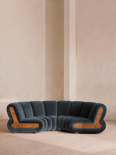 a blue couch sitting on top of a hard wood floor next to a white wall