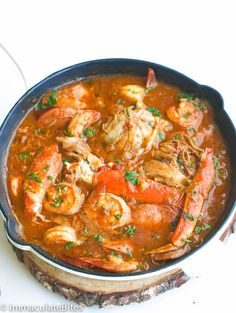 a pan filled with shrimp and carrots on top of a table