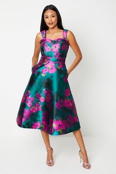 Striking floral print in vibrant hues Elegant panelled bodice for a flattering fit Midi length with a full, flared skirt Wide shoulder straps for comfort and support Organza fabric adds luxurious texture and sheen Make a statement at your next special occasion with this enchanting floral print midi dress from Coast. The panelled bodice creates a figure-flattering silhouette, while the full, flared skirt adds a touch of drama and movement. Perfect for weddings, race days, or formal garden parties, this dress radiates sophistication and elegance. Style it with strappy metallic heels and a clutch bag for a polished ensemble. For cooler evenings, drape a lightweight pashmina over your shoulders. The versatile design allows for easy accessorising - opt for delicate drop earrings to complement Midi Wedding Guest Dress, Full Flared Skirt, Coast Dress, Floral Print Midi Dress, Print Midi Dress, Prom Outfits, Feather Dress, Organza Fabric, Dresses Floral