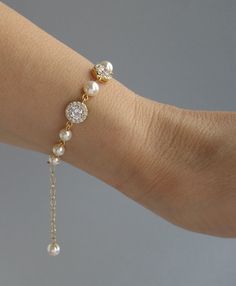 a close up of a person wearing a bracelet with pearls