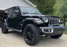 a black jeep parked in front of a house