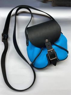 "Mini Backpack style women's leather purse. This backpack style bag is 100% handmade using 100% leather and completely hand stitched using waxed thread and the superior saddle stitch method. The purse features a strap that adjusts roughly 2\" longer and shorter. The bag opens and closes with a laced cinch covered by a top flap that buckles shut for great security. Purse is large enough for most phones, wallets, pens etc. ! Great look to go along with any outfit, adults or kids! Purse hangs appro Leather Backpack Bag For Gift, Leather Backpack Suitable As A Gift, Leather Backpack Perfect For Gift, Leather Satchel With Mobile Phone Bag For School, Blue Leather Satchel As Gift, Leather Pouch Shoulder Bag For School, Blue Leather Backpack With Removable Pouch, Handmade Blue Leather Satchel, Leather School Satchel Pouch