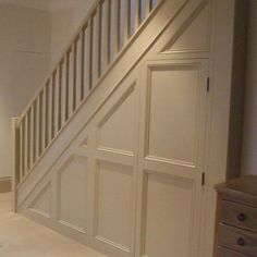 an empty room with white walls and wooden stairs