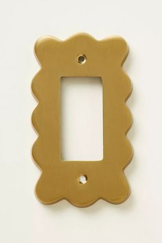 a gold plate with a scalloped edge on a white surface, it has a hole in the middle