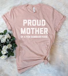 This "Proud Mother Of A Few Dumbass Kids" design is the perfect funny shirt for Mom! Makes a great Birthday Day gift or Mother's Day present! Mother's Day Graphic Tee With Funny Text, Mother's Day Funny Text Graphic Tee, Fun Slogan T-shirt For Fan Merchandise, Funny Graphic Print T-shirt For Mother's Day, Funny Mother's Day Graphic Print T-shirt, Funny Mother's Day Graphic T-shirt, Funny Print T-shirt For Mother's Day, Funny Short Sleeve T-shirt For Mother's Day, Funny Text Print T-shirt For Mother's Day