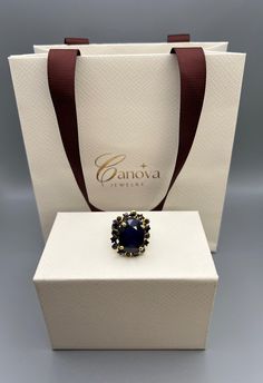 Add a touch of elegance to your wardrobe with this stunning handmade cocktail ring from Canova Jewelry. The oval-shaped blue sapphire stone is set in 925 sterling silver, giving it a timeless and classic look. The ring is perfect for any occasion, whether it's a special event like Mother's Day or Graduation, or an everyday accessory. The ring is nickel-free, making it safe and comfortable to wear. It features excellent cut grade and the natural creation of the gemstone adds to its unique beauty. The ring is a size 8. With its Art Deco era and bohemian theme, this ring is a perfect addition to any jewelry collection. Luxury Oval Cabochon Ring For Gift, Luxury Oval Cabochon Ring As Gift, Luxury Sapphire Ring For Gift, Luxury Sapphire Ring With Gemstone Accents For Formal Wear, Luxury Sapphire Ring With Gemstone Accents For Formal Occasions, Luxury Formal Sapphire Ring With Gemstone Accents, Blue Cabochon Sapphire Ring Gift, Elegant Tanzanite Rings With Gemstone Accents, Blue Gemstone Rings For Evening