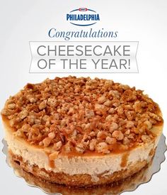 congratulations cheesecake of the year on top of a glass cake plate with caramel toppings