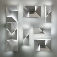 several white shelves are arranged in the shape of squares and rectangles on a wall