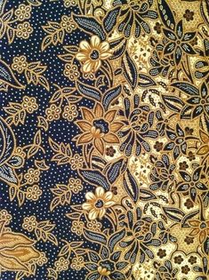 an intricate gold and blue design on fabric with flowers, leaves and dots in the background