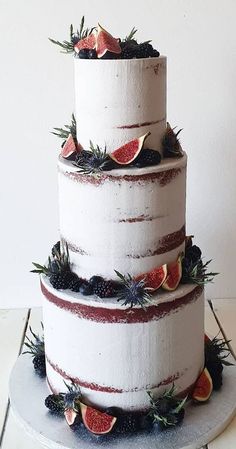 a three tiered cake with fresh fruit on top