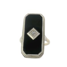 This stunning Black Onyx and Diamond Art Deco Ring features intricate filigree detailing and a bold black onyx centerpiece with a center diamond. A unique and timeless piece, perfect for adding elegant sophistication to any outfit. Jewelry Style : Ring Metal Type : 14K Gold  Diamond : 1 round diamond  Ring Size : 6.75 : Can be sized by your jeweler Black Onyx : Approximately 23mm x 10mm estate piece, sold as is, all weights are estimates Elegant Onyx Jewelry With Diamond Accents, Formal Black Jewelry With Diamond Accents, Formal Black Engraved Jewelry, Art Deco Black Engraved Jewelry, Art Deco Onyx Ring With Black Enamel, Black Onyx Rings With Diamond Accents, Formal Black Ring With Filigree Detailing, Classic Black Filigree Rings, Classic Black Filigree Jewelry