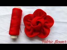 a spool of thread next to a red flower on a white surface with text that reads fabric flower