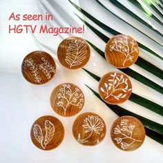 six wooden buttons with white flowers on them and palm leaves in the background text reads as seen in hgt tv magazine