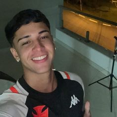 a young man is smiling while taking a selfie in front of an empty stage