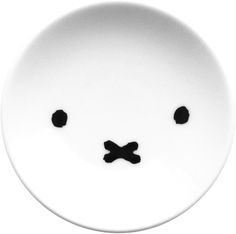 a white plate with black dots and a face drawn on the side, in front of a white background