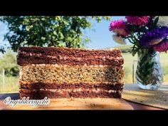 a piece of cake sitting on top of a table next to a vase with flowers