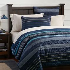 a bed with blue and white striped comforter