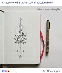 an open notebook with a drawing of a flower on it and a pen next to it