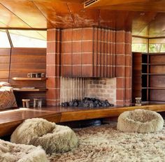 a living room filled with furniture and a fire place in the middle of it's walls