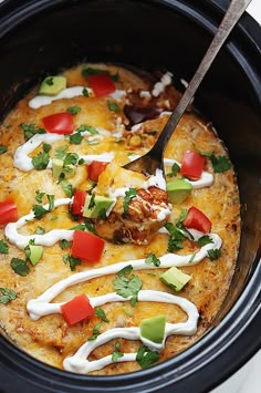 a crock pot filled with mexican food and garnished with cilantro