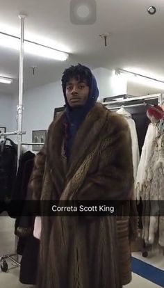 a man wearing a fur coat in a clothing store