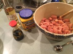 a bowl filled with meat sitting on top of a counter next to an electric stove