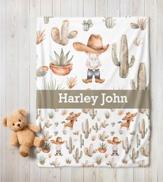 a teddy bear is sitting next to a personalized blanket with cactus and cowboy theme