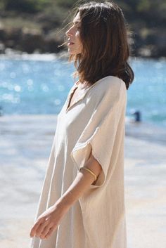 Style // Whether you call it beige, cream or off-white, our Moon is the perfect oatmeal color kaftan When comfort meets style, the Cala Kaftan features a billowy, shapeless silhouette and mid-length. With a v-neck silhouette, wide sleeves and two side slits, it promises to be your go-to look for that cozy, effortless look. The lightweight linen-cotton blend fabric is extra soft, to ensure you won't ever want to take it off Fabric Note // Made in Italy from a Linen & Cotton blend Sizing Advice // Casual Beige Kaftan For Beach, Beach Beige Relaxed Fit Tunic, Oversized Beige Tunic For Summer, Oversized Beige Tunic For Spring, Casual Beige Kaftan For Spring, Chic Beige Tunic For The Beach, Bohemian Beige Tunic With Relaxed Fit, Beige Flowy Kaftan For Summer, Beige Relaxed Fit Beach Tunic